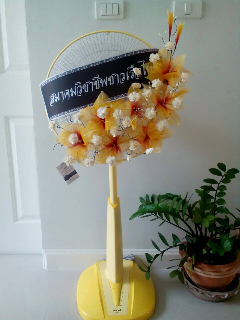 พวงหรีดพัดลมสไลด์ขนาด 16 นิ้ว ดอกใบยางสีเหลืองส้ม 1 มุม